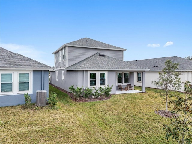 rear view of house featuring a lawn and central air condition unit