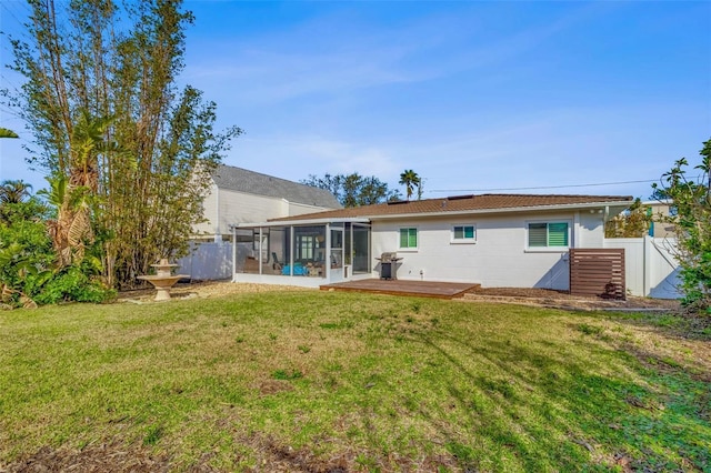 back of house with a wooden deck, a yard, and a sunroom