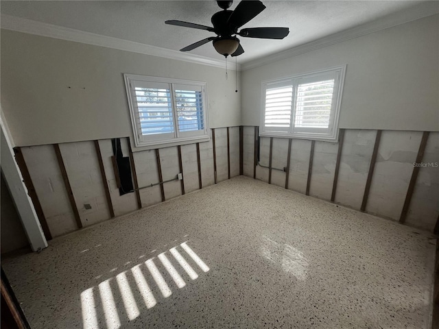 spare room featuring a ceiling fan and crown molding