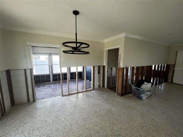 spare room with speckled floor, an inviting chandelier, and crown molding