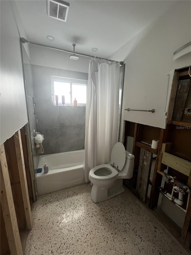 full bathroom featuring visible vents, toilet, speckled floor, and shower / tub combo with curtain