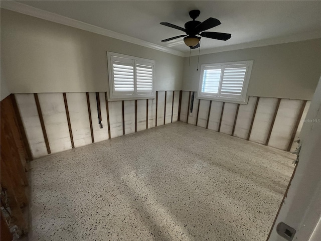 unfurnished room with speckled floor, crown molding, and ceiling fan