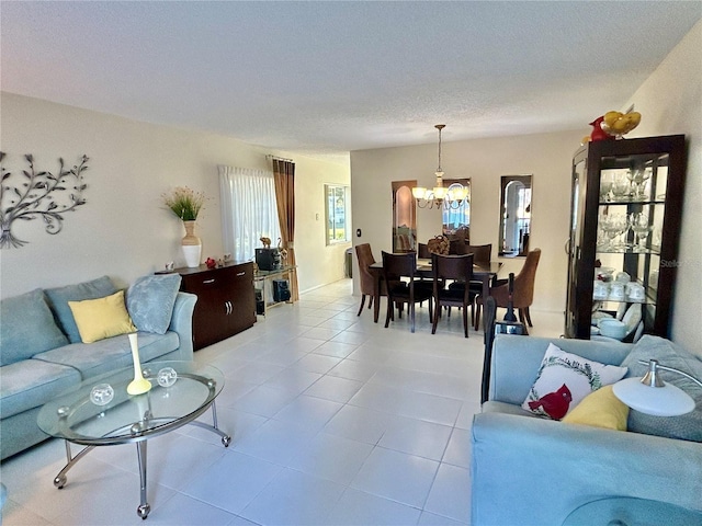 living room featuring light tile patterned floors, a notable chandelier, and a textured ceiling