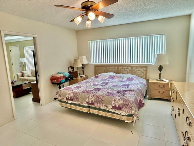 tiled bedroom with a textured ceiling and ceiling fan