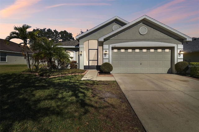 single story home with a garage and a lawn