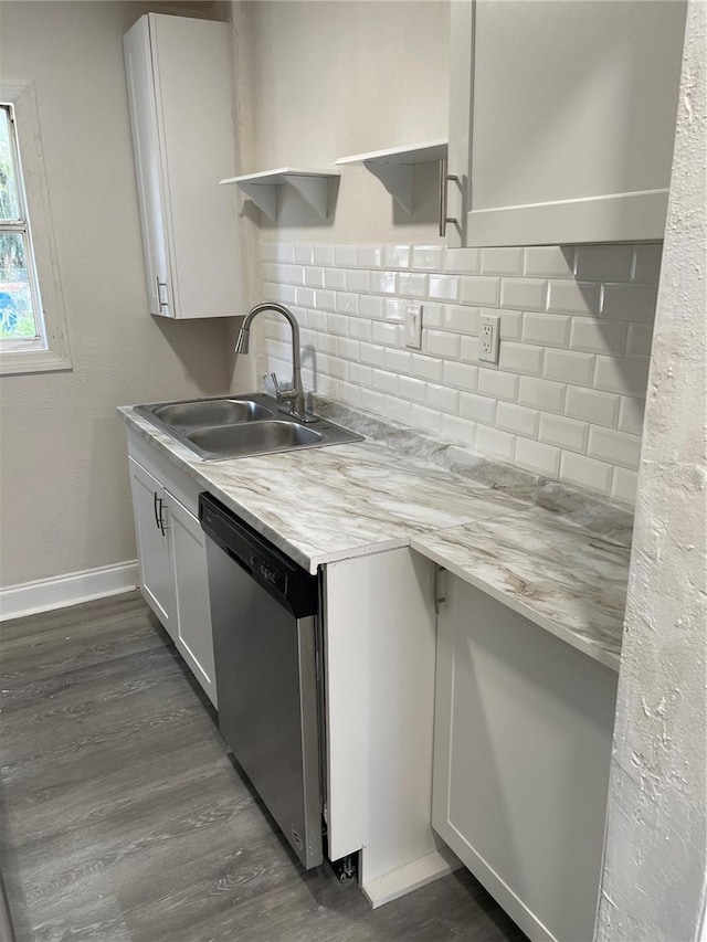 kitchen with tasteful backsplash, dark hardwood / wood-style floors, stainless steel dishwasher, sink, and white cabinets