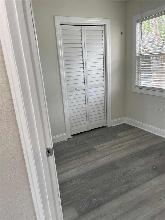 unfurnished bedroom featuring a closet and dark hardwood / wood-style floors