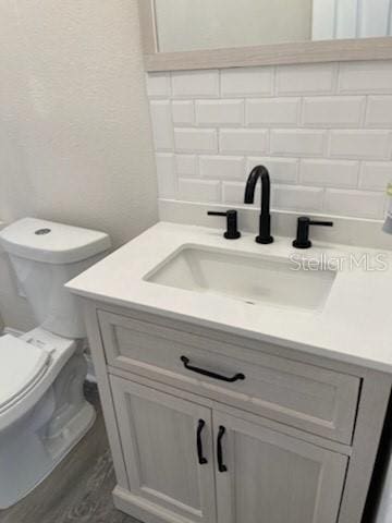 bathroom featuring toilet, hardwood / wood-style flooring, and vanity