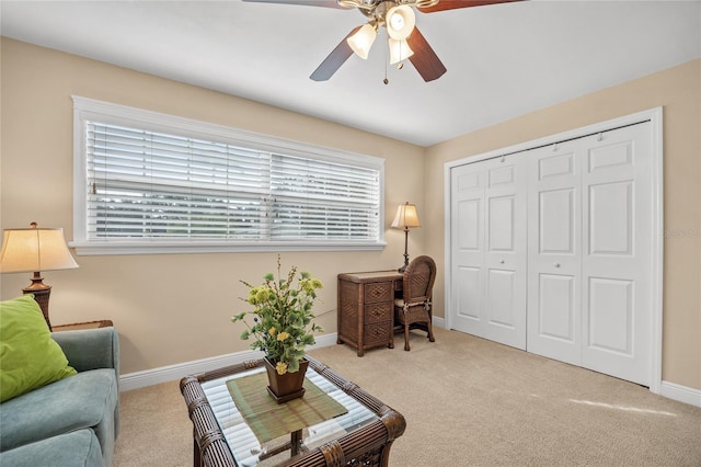 living area featuring ceiling fan and light colored carpet