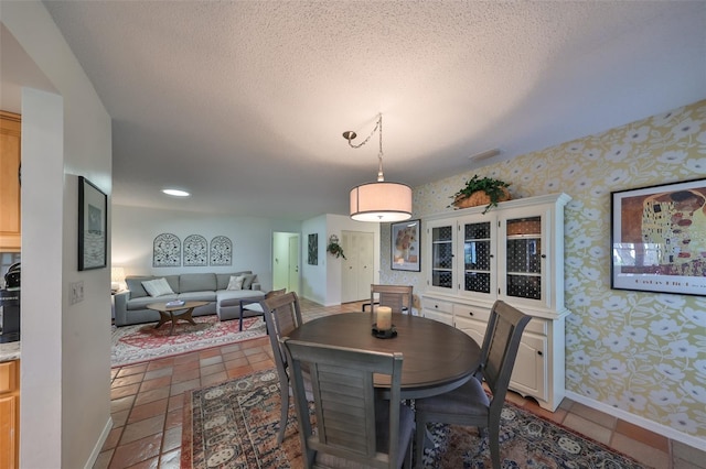 tiled dining area featuring a textured ceiling