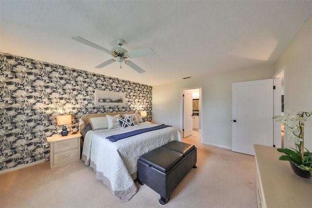 bedroom with light carpet, ceiling fan, and ensuite bath