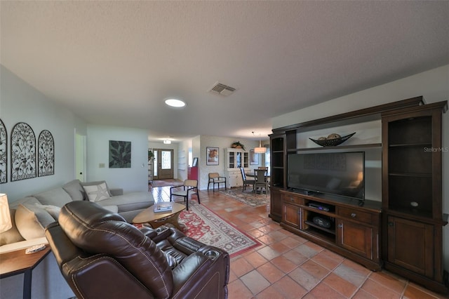 living room with light tile patterned floors, french doors, and a textured ceiling