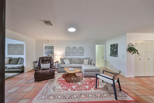 tiled living room featuring a textured ceiling