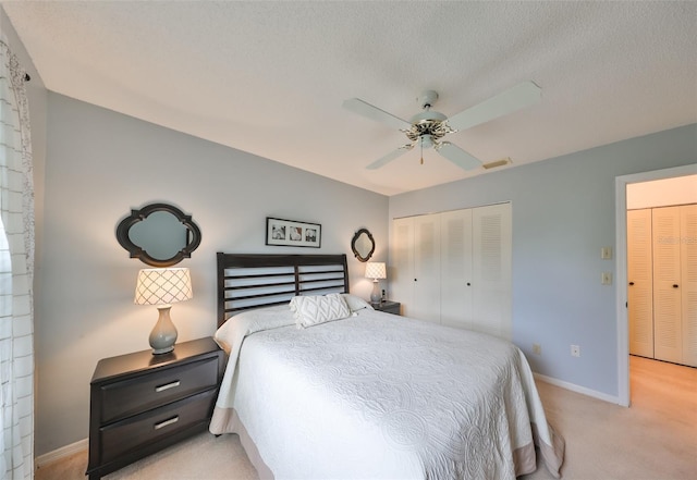 bedroom featuring ceiling fan, light carpet, a closet, and a textured ceiling