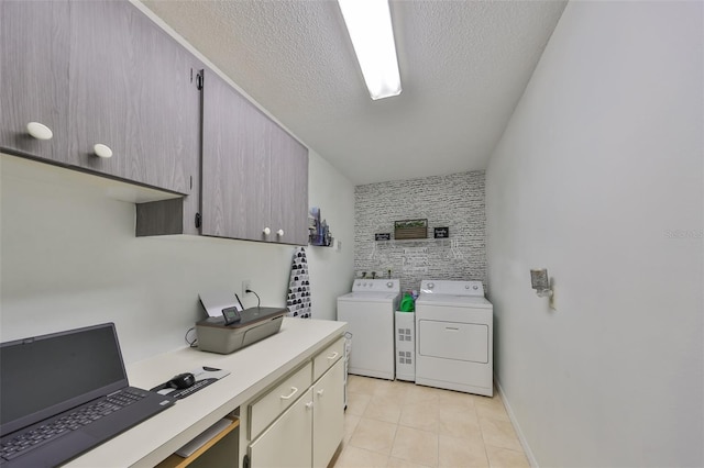 clothes washing area featuring a textured ceiling, cabinets, light tile patterned flooring, and washer and clothes dryer