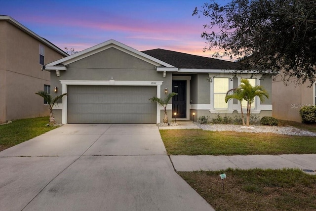 ranch-style house with a garage and a yard