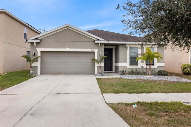 single story home featuring a garage and a front lawn