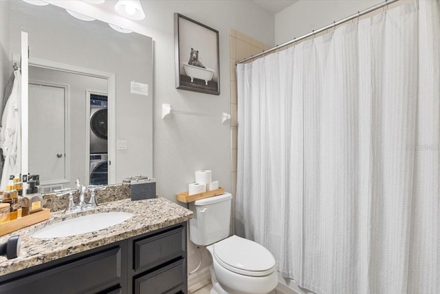 bathroom featuring vanity, stacked washer and clothes dryer, and toilet