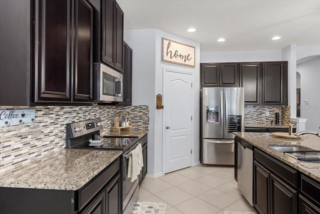 kitchen featuring tasteful backsplash, sink, light stone counters, and stainless steel appliances