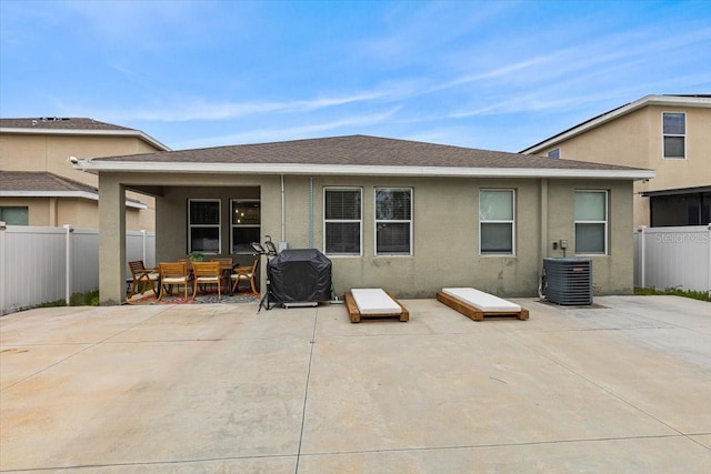 rear view of house with central AC unit and a patio area