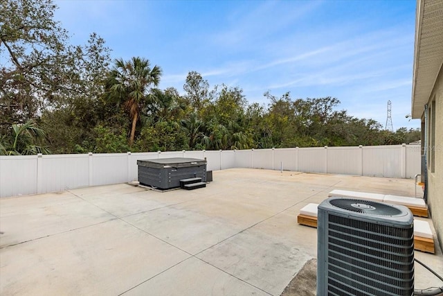 view of patio / terrace with a hot tub and central AC