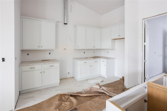 kitchen featuring white cabinetry and lofted ceiling