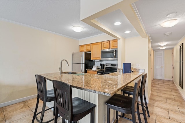 kitchen featuring a kitchen breakfast bar, kitchen peninsula, light stone countertops, ornamental molding, and stainless steel appliances