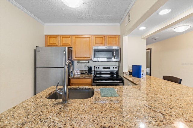 2506 N Rocky Point Dr Unit 272, Tampa, FL 33607 - kitchen with appliances with stainless steel finishes, a sink, light stone counters, ornamental molding, and a textured ceiling
