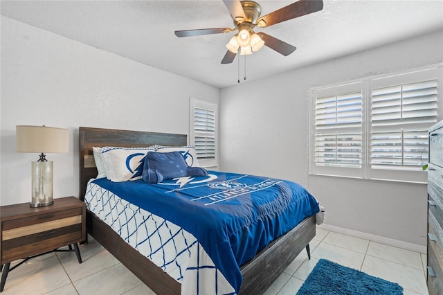 tiled bedroom featuring a textured ceiling and ceiling fan