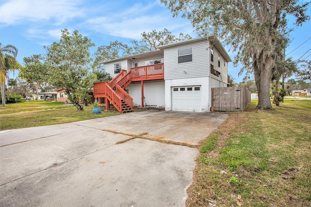 view of front of home with a garage, a front lawn, and a wooden deck