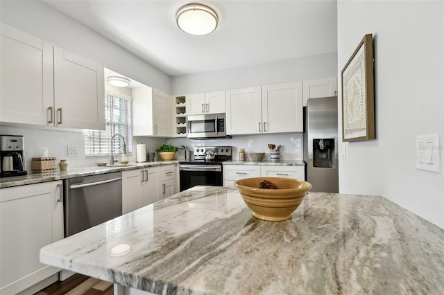 kitchen featuring white cabinetry, light stone countertops, and appliances with stainless steel finishes