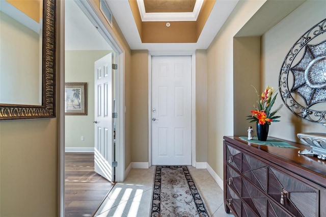 foyer featuring a raised ceiling and light tile patterned flooring