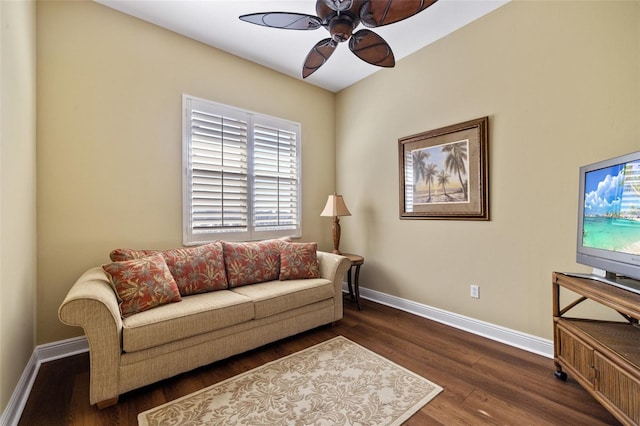 living room featuring dark wood-type flooring and ceiling fan