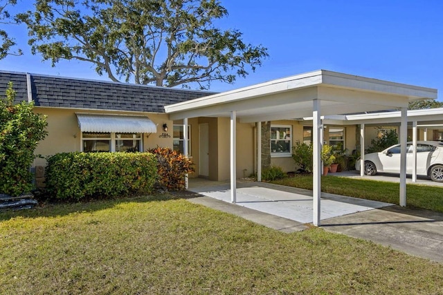 exterior space with a lawn and a carport