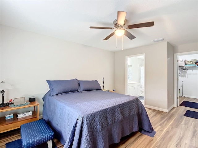 bedroom with ceiling fan, light hardwood / wood-style floors, a closet, and ensuite bath