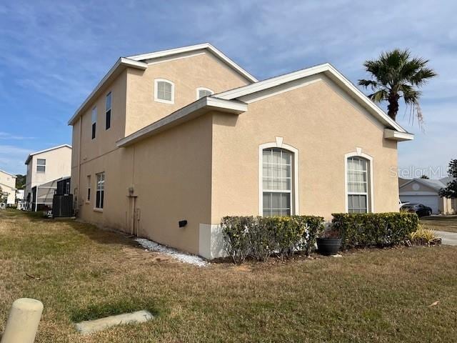 view of side of property featuring cooling unit and a lawn