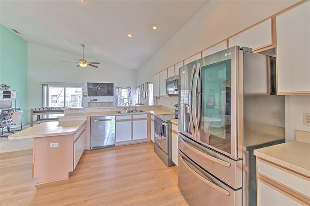 kitchen with white cabinetry, appliances with stainless steel finishes, kitchen peninsula, and light wood-type flooring