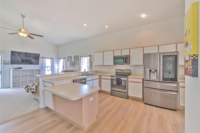 kitchen with sink, white cabinetry, stainless steel appliances, light hardwood / wood-style floors, and kitchen peninsula