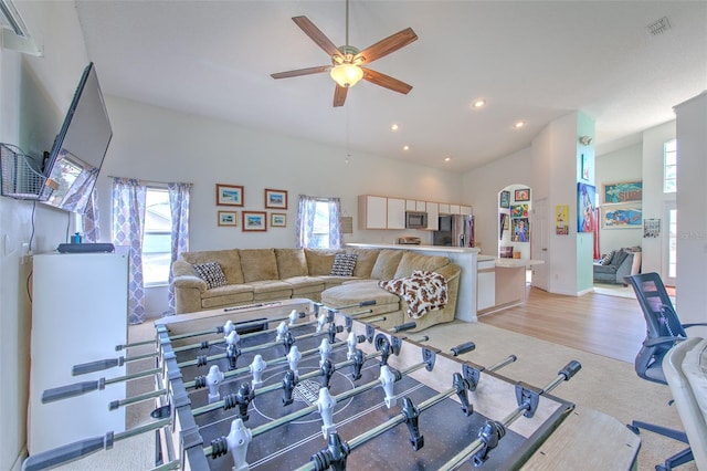 carpeted living room featuring ceiling fan, plenty of natural light, and high vaulted ceiling