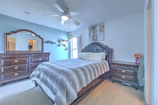 carpeted bedroom with ceiling fan and a textured ceiling