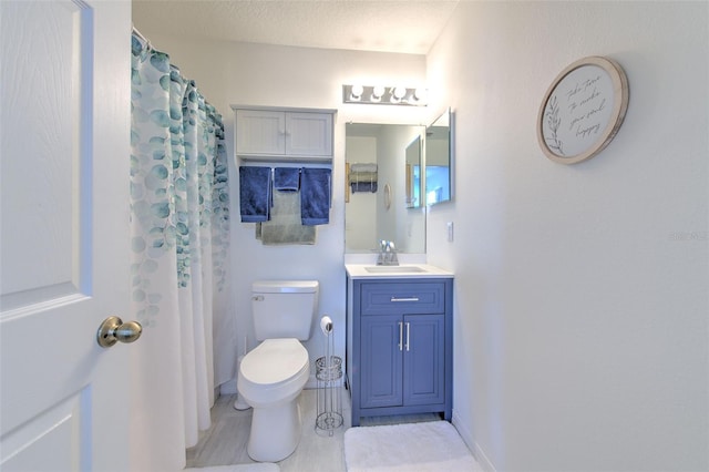 bathroom with vanity, a textured ceiling, a shower with curtain, and toilet