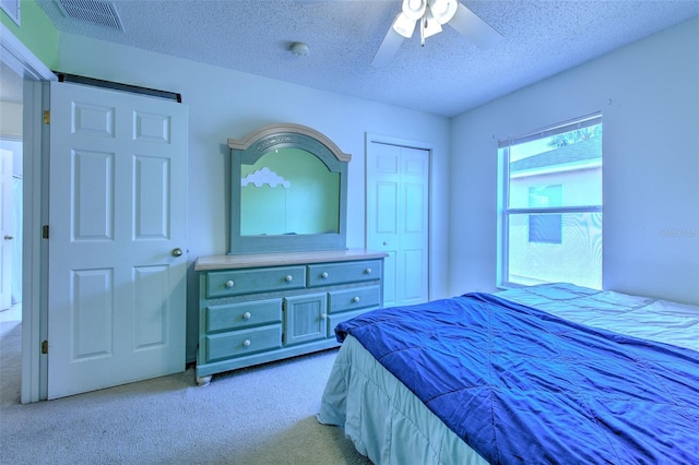 carpeted bedroom with ceiling fan and a textured ceiling