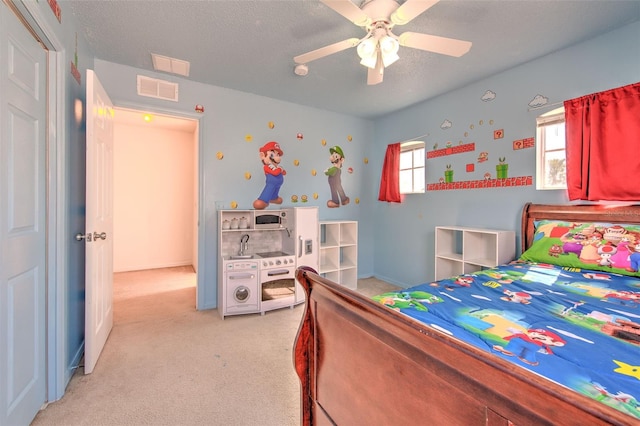 carpeted bedroom featuring ceiling fan and a textured ceiling