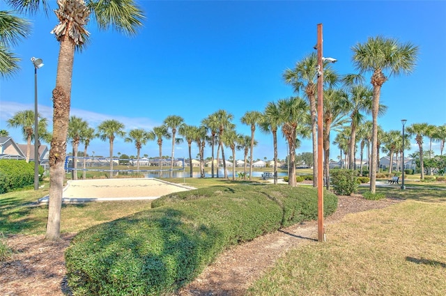 surrounding community featuring a water view, a yard, and volleyball court