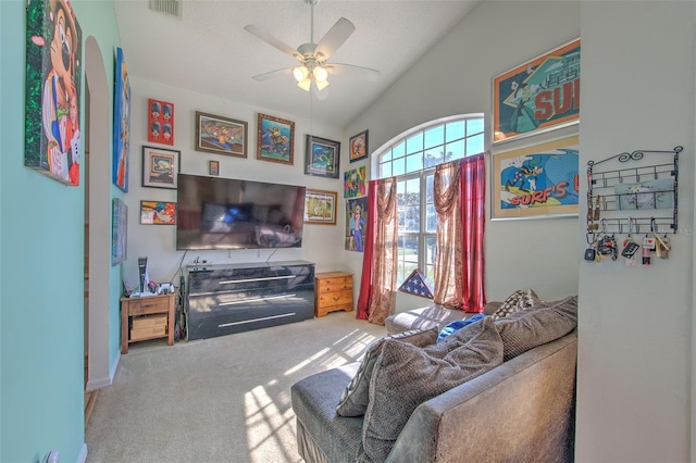 carpeted living room with ceiling fan and lofted ceiling