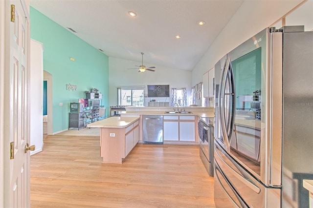 kitchen featuring appliances with stainless steel finishes, white cabinetry, sink, kitchen peninsula, and light wood-type flooring