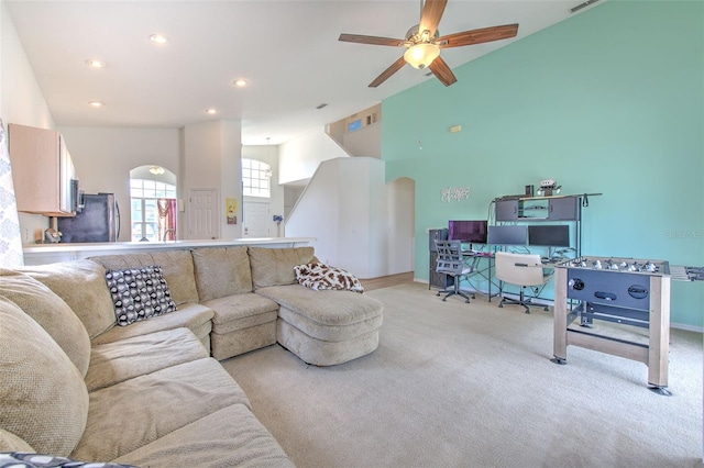 carpeted living room with ceiling fan and vaulted ceiling