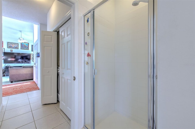 bathroom featuring a shower with shower door, tile patterned floors, and ceiling fan