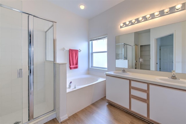 bathroom with vanity, hardwood / wood-style floors, and plus walk in shower