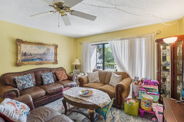 living room featuring ceiling fan and a textured ceiling